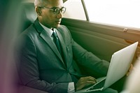 Businessman using laptop working in the car