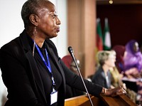 A Middle African Descent Woman Speaking into a Microphone