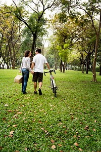 Couple walking and holding hands in the park