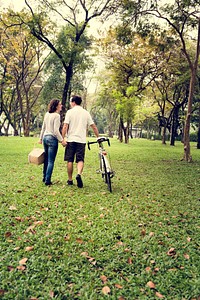 Couple holding hand and walking together in the park