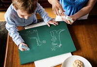 Little boy drawing dinosaurs with chalk