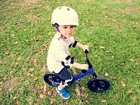 Kid riding a bike in a park.