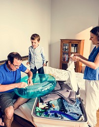 Son is helping their parent to pack a clothes.