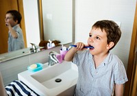 Little boy brushing his teeth on his own