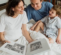 Family Looking Photobook Together at the Bedroom