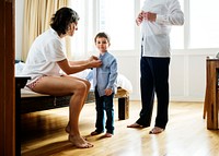 Mother helping son to get dressed