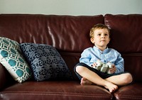 Boy playing video games in the sofa