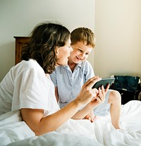 Son and mother using a digital device together