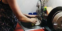 Woman is cleaning dishes at home.