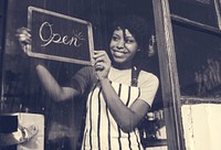 Woman is hanging blackboard with open word for service