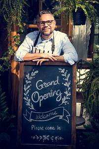 Adult Man Standing with Grand Opening Sign