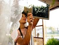 Woman Hanging Open Sign by the Glass Window