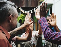 Group of diverse people with hands raised teamwork