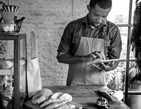 Adult Man Using Tablet in Bakery Shop