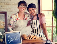 Small business partnership women friends at bakery shop smiling