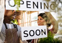 Black Couple Showing Opening Soon Paper Sign