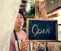 Woman is hanging blackboard with open word for service