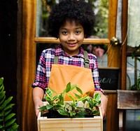 Little Boy Standing Carryin Small Plants in Wooden Tray