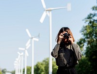 Woman at windmill field taking a photo