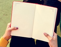Hand Holding Reading Diary Notebook