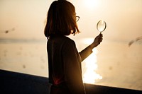 Silhouette of woman holding magnifying glass