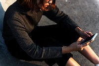 Girl sitting on the ground using her phone