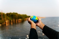 Hands holding out a small globe