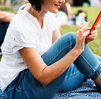 An Adult Woman Sitting in The Park Using Mobile Phone