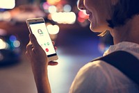 Woman using smart phone walking on street night time