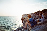 Women taking photo by seashore