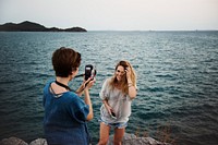 Women taking photo by seashore