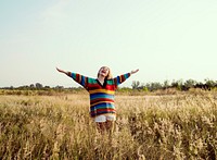 Woman with arms outstretched in the middle of the meadow