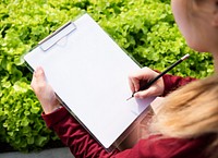 Close up of woman writing on a clipboard paper