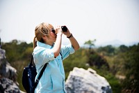 Young woman on a mountain with binoculars