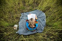 Woman reading book in the middle of a field