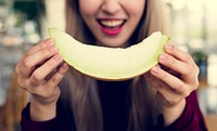 Woman eating melon honeydew with happiness smile