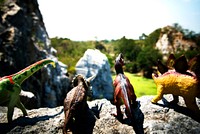 Group of dinosaur toys on a rock