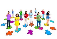 Group of multi-ethnic people standing on pictures of puzzle pieces wth their electronic devices.