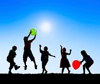 Silhouettes of Cheerful Children Playing Balloons Outdoors