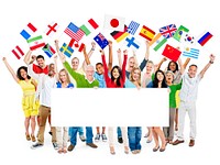 Large group of diverse cheerful multi-ethnic casual people celebrating while holding flags and a white placard.