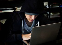 Young guy in a hoodie using laptop