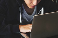 Young guy in a hoodie using laptop