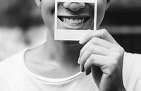 Young asian man holding photograph cover his mouth