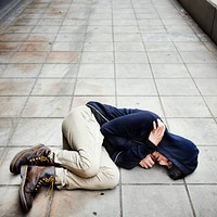 Guy in a hoodie fetal position on the floor