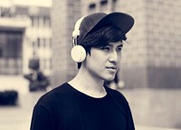 Asian guy listening music by headphones