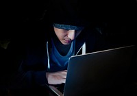 Young guy in a hoodie using laptop