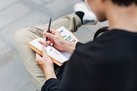 Asian guy drawing and sketching designs on his notebook