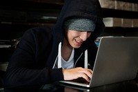 Young guy in a hoodie using laptop