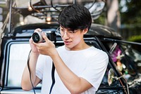 Asian guy takes photo on street