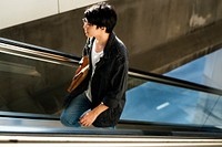 Handsome asian guy on the escalator